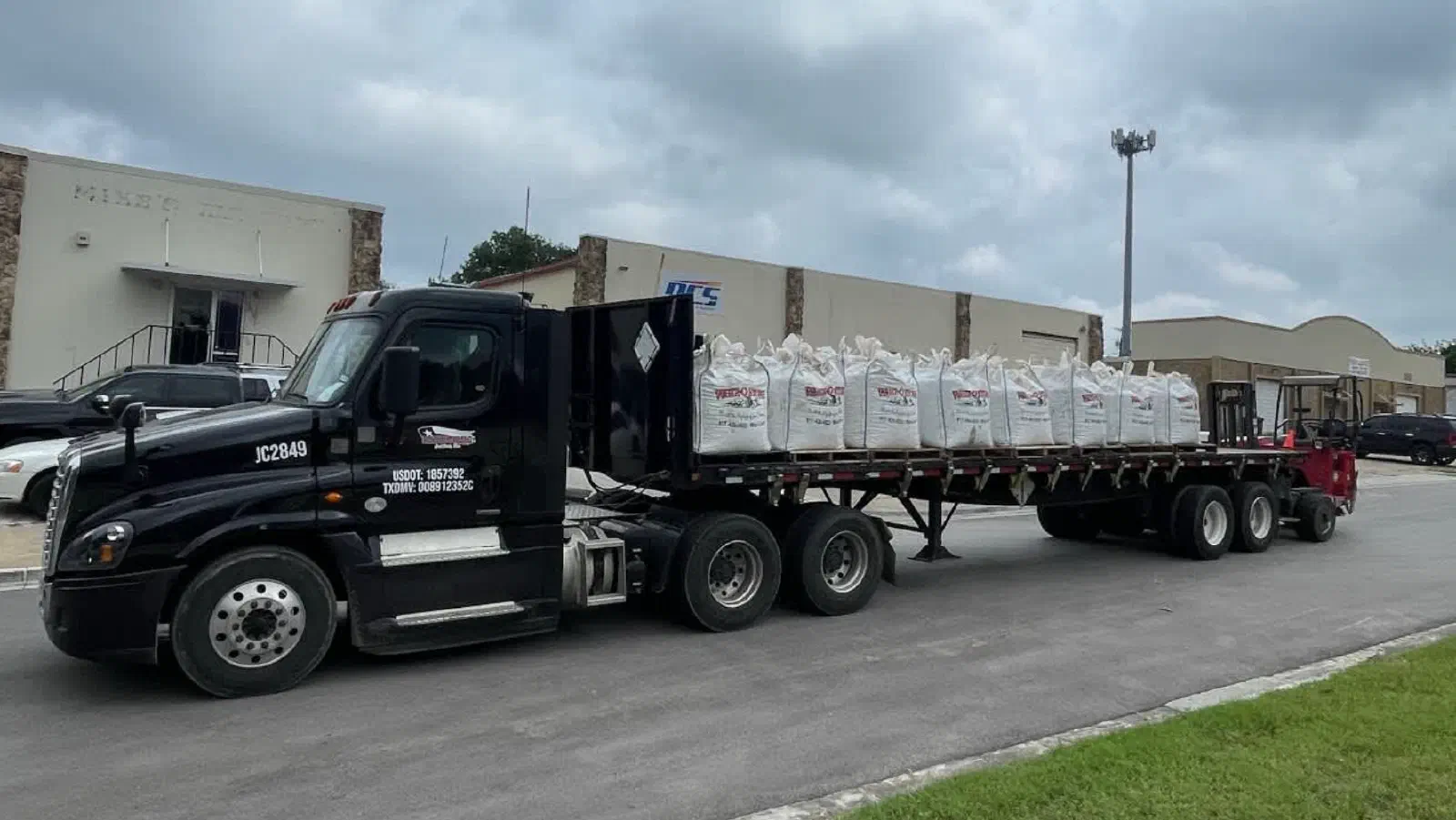 Black truck with a piggyback forklift mounted on the back for Moffett delivery. Black truck with a piggyback forklift mounted on the back for Moffett delivery.