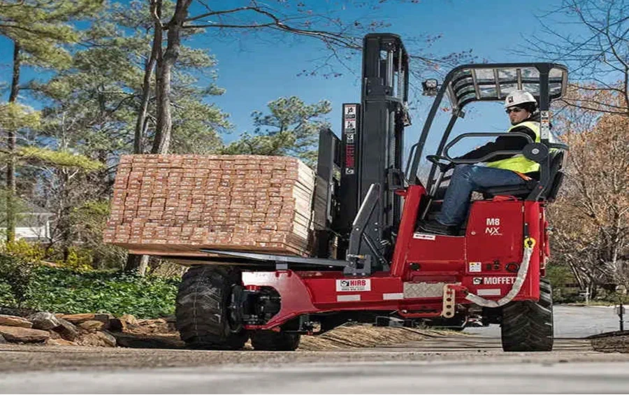 Red piggyback forklift unloading lumber at a jobsite Red piggyback forklift unloading lumber at a jobsite