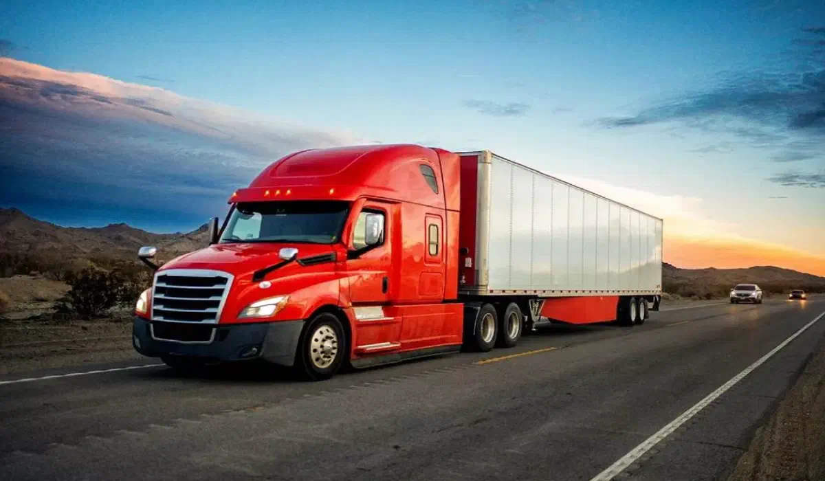 Red semi-truck hauling freight on the highway. Red semi-truck hauling freight on the highway.