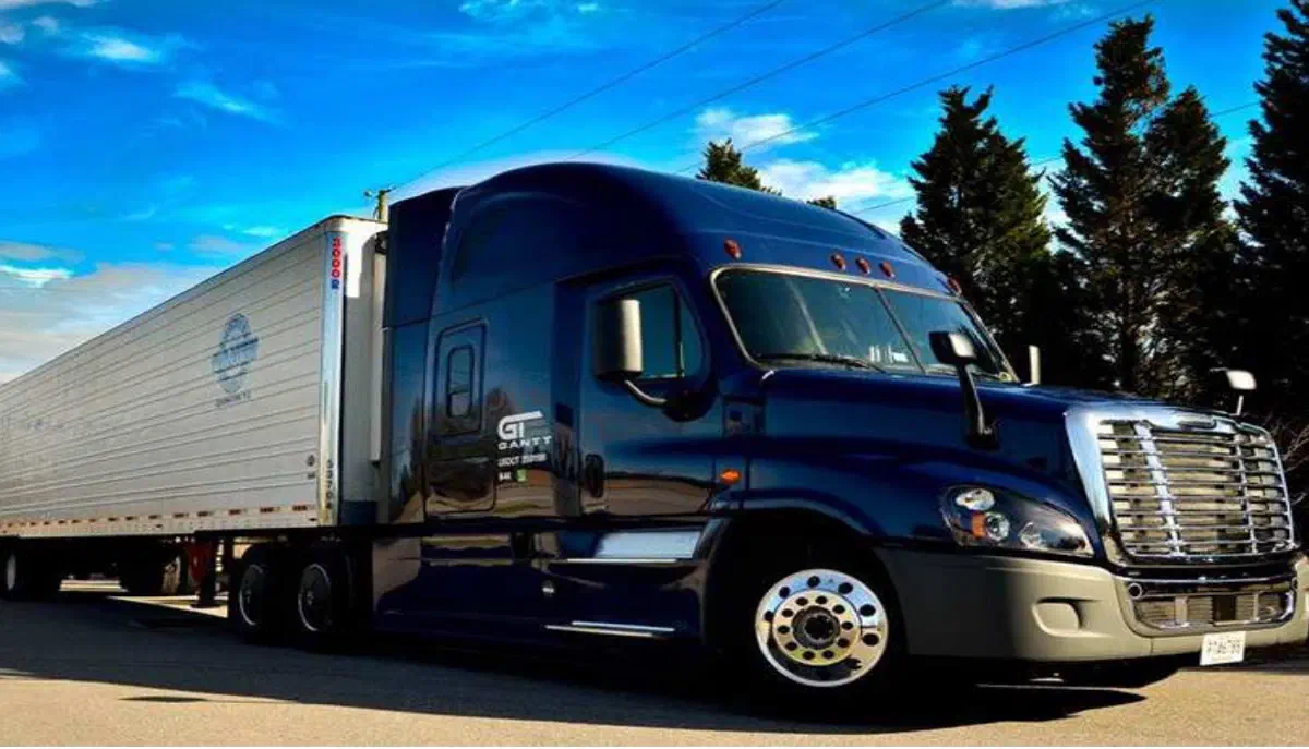 Dark blue semi-truck pulling a refrigerated trailer. Dark blue semi-truck pulling a refrigerated trailer.