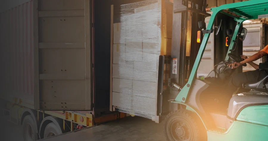 Forklift loading palletized medical supplies into a trailer