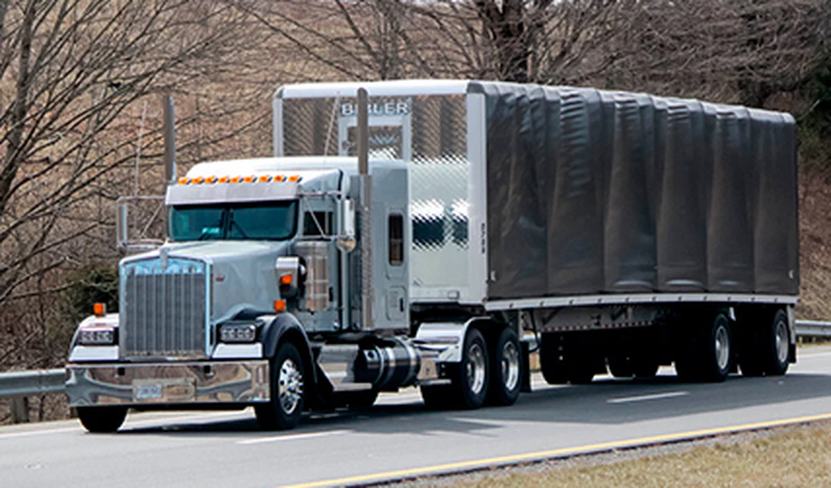 Tractor pulling a Conestoga trailer with the rolling tarp system closed
