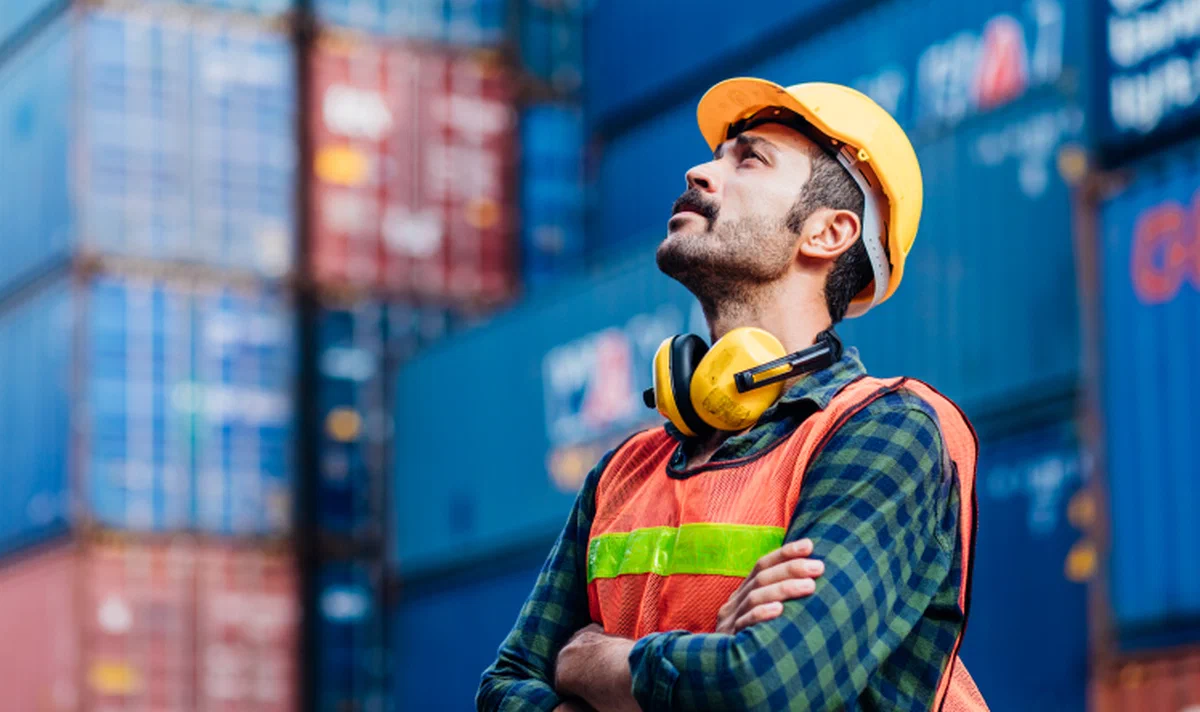 A man looking at freight containers.