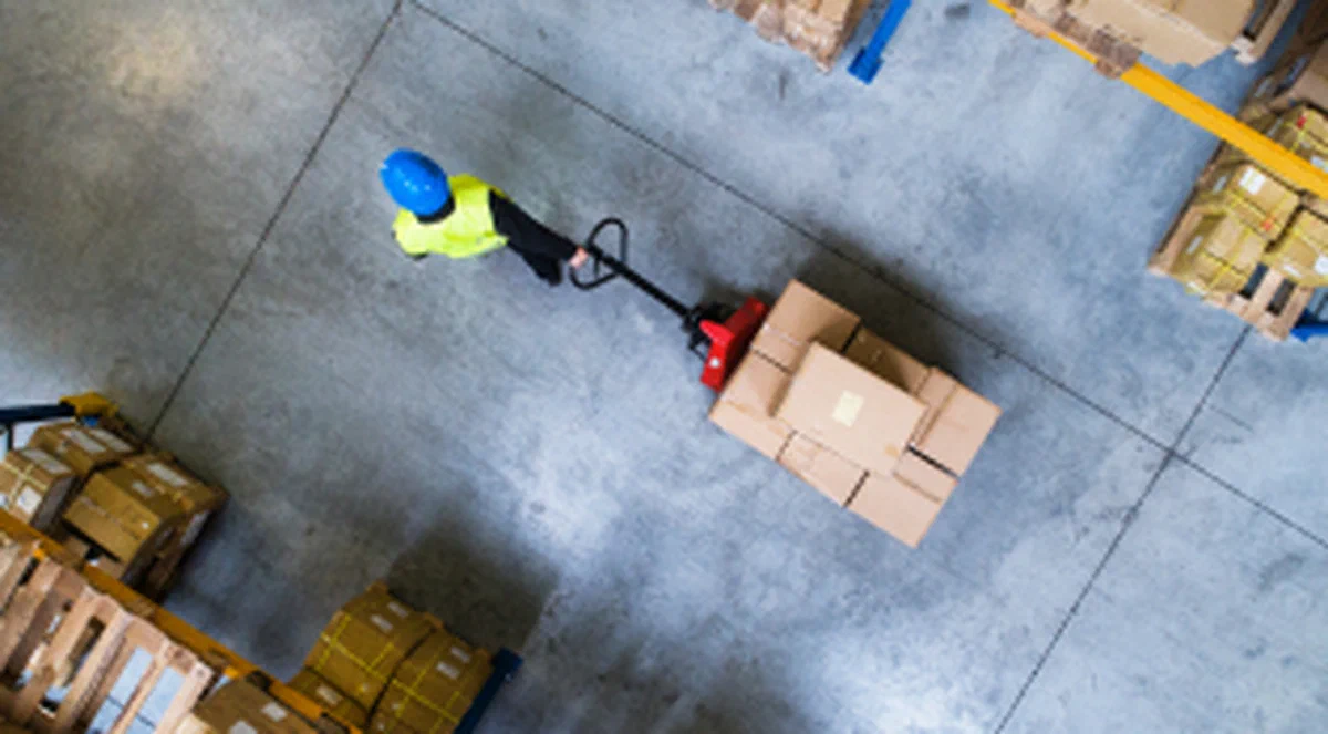 Warehouse worker moving a pallet during a freight transfer.